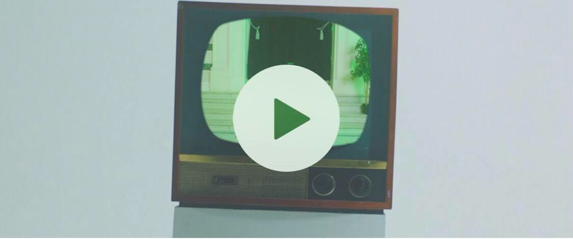 A vintage television with a play button, the site’s video frame